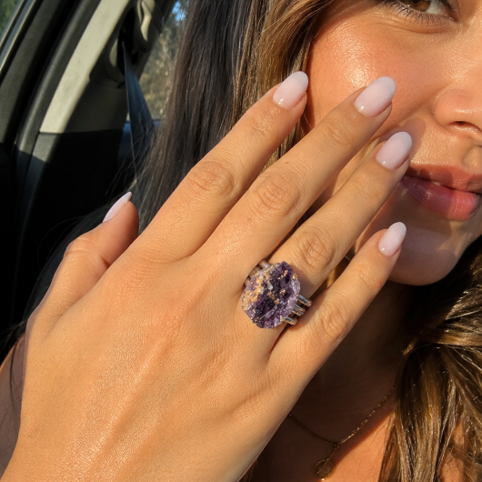 Woman wearing the Violet Earth Mineral Ring in warm sunlight